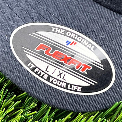 Navy blue Flexfit hat with a black and silver sticker label showing the brand name and size L, XL.