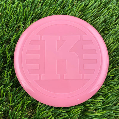 Bright pink Kastaplast K Mini Marker disc with a large embossed "K" logo on its surface.