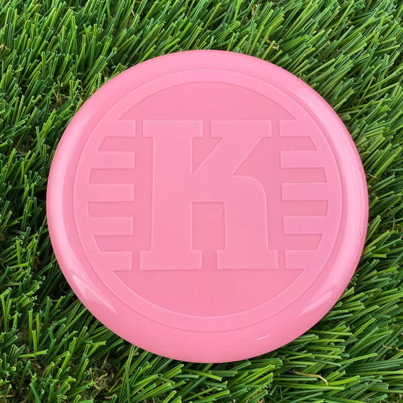 Bright pink Kastaplast K Mini Marker disc with a large embossed "K" logo on its surface.