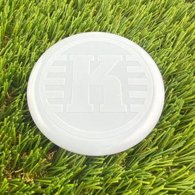White Kastaplast K Mini Marker disc golf marker with a large embossed "K" logo centered on its surface.