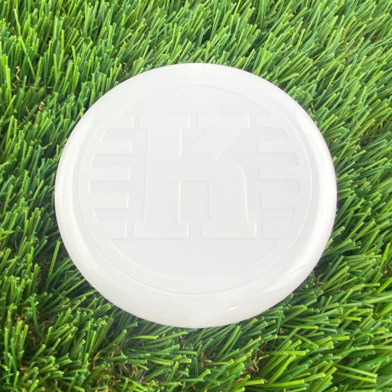 White Kastaplast K Mini Marker disc with an embossed K logo and a smooth, glossy surface.