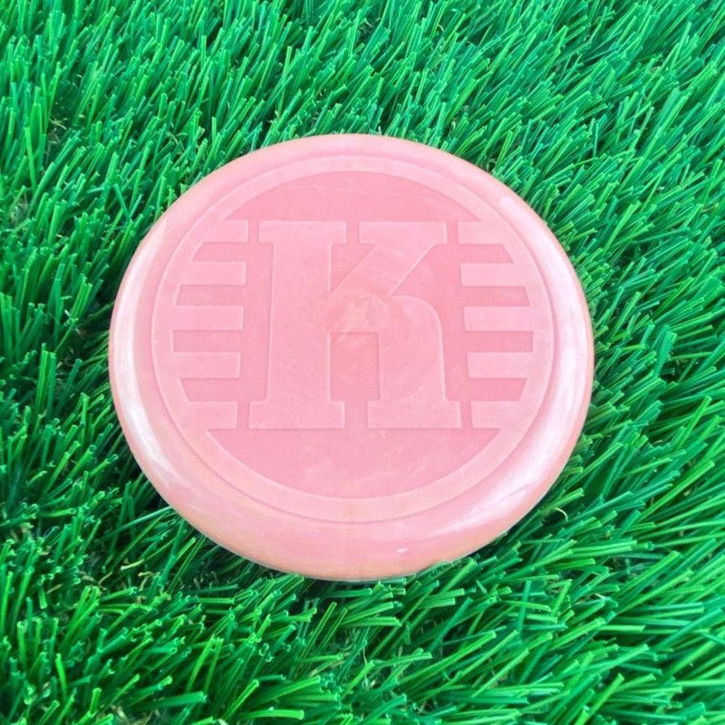 Pink Kastaplast K Mini Marker disc with a prominent embossed K-logo on its flat top surface.