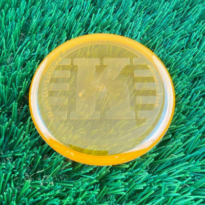 Translucent orange Kastaplast K Mini Marker disc golf disc with a large debossed "K" logo on top.