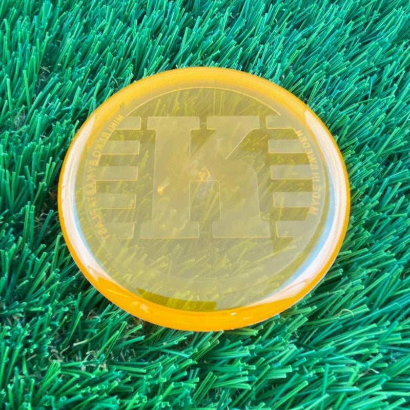 Translucent orange Kastaplast K Mini Marker disc golf disc with a large debossed "K" logo on top.