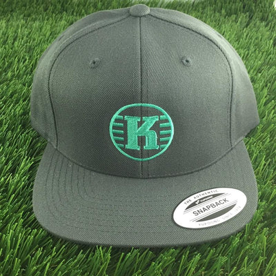 Dark gray Kastaplast Yupoong snapback hat with a vibrant green "K" logo in a circle on the front.