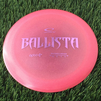 Translucent pink Latitude 64 Opto Air Ballista distance driver with purple "BALLISTA" text and flight numbers.
