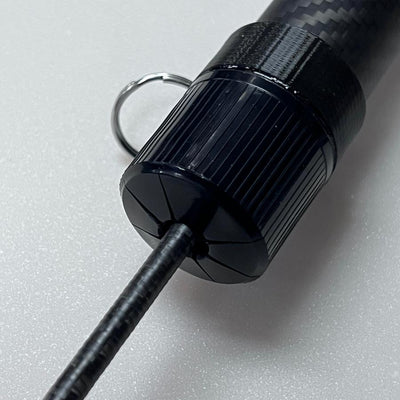Black carbon fiber Max Stick XF16 ball retriever with a textured ergonomic grip and a metal keyring attachment.