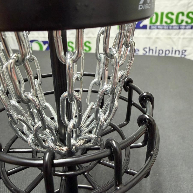 MVP Black Hole Micro disc golf basket, with shiny silver chains and a black metal frame.