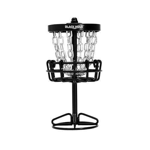 Black MVP Black Hole Micro disc golf basket with shiny silver chains and a sturdy metal base.