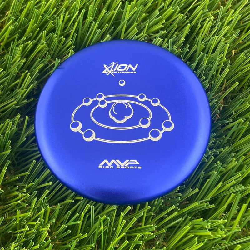 Round blue MVP Disc Sports Ion putter disc golf marker with a silver metallic planet and ring graphic.