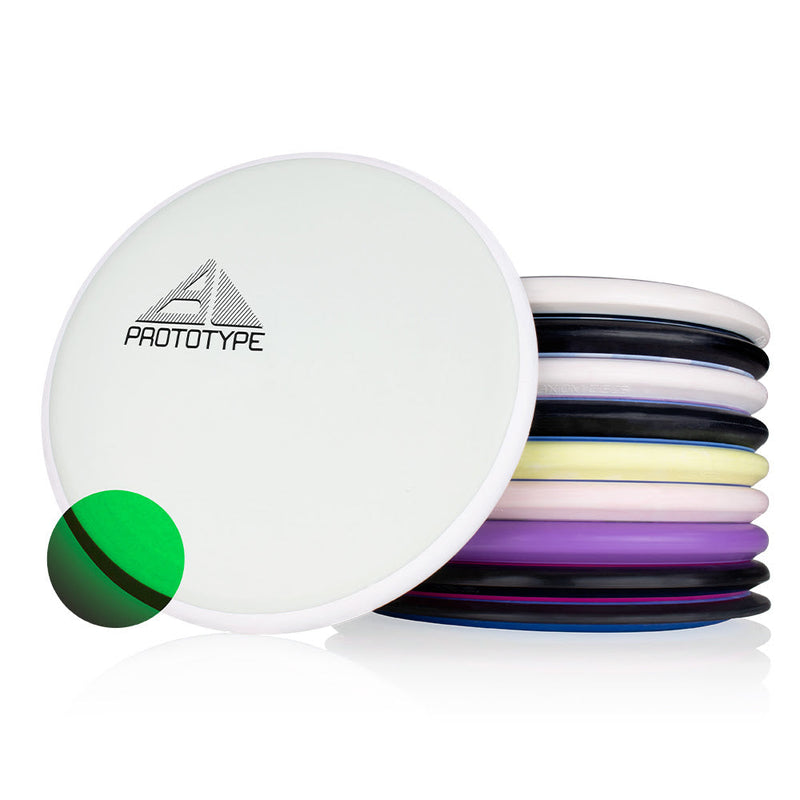 Stack of colorful MVP disc golf discs with one white "Prototype" disc in front featuring a green glow circle.