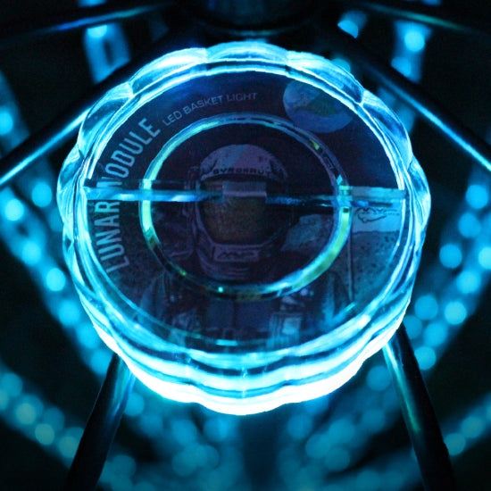 Mvp lunar module led basket light, illuminated with a bright blue glow against a dark, bokeh-filled background.