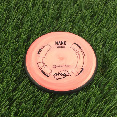 Orange MVP Nano Mini Disc golf marker with black outline graphics and a black overmold rim.