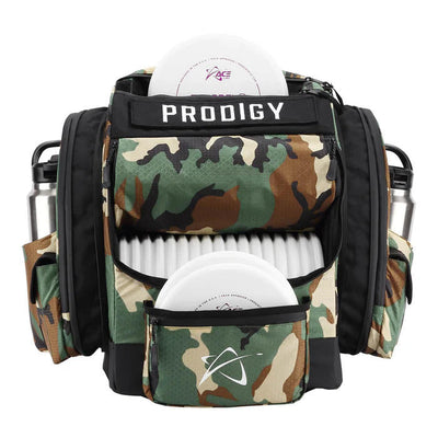 Woodland camouflage Prodigy BP 1 V3 ripstop disc golf backpack with two white discs and two silver water bottles.