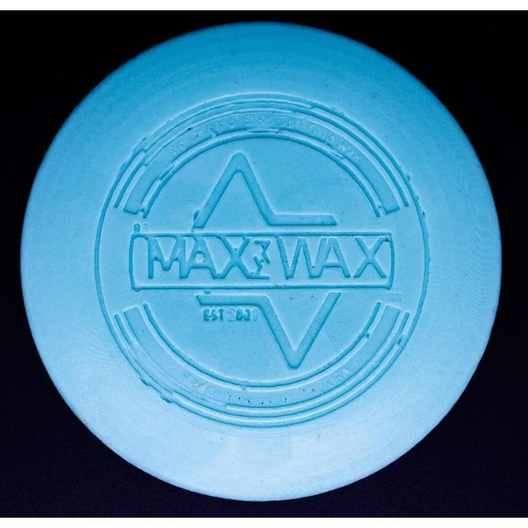 A round, light blue dg max wax mini grip wax with "max wax" embossed at the center, glowing in the dark.