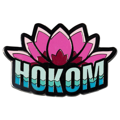Pink lotus enamel pin with layered petals and "HOKOM" word art in wavy blues and greens.