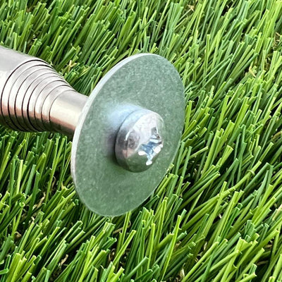 Shiny chrome inzone kwik stik mini round hook on a silver-grey washer, partially submerged in green artificial turf.