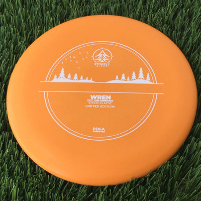 Solid orange Stokely Strato Wren disc golf putter with a white-outlined limited edition forest stamp.
