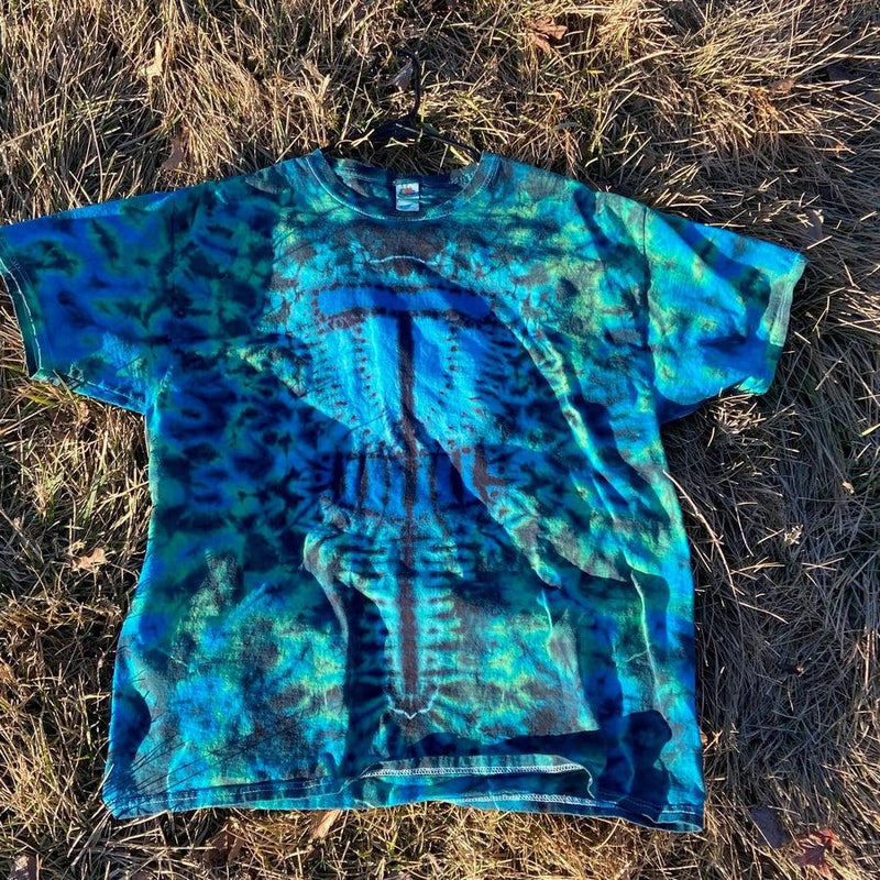 A vibrant blue and green tie-dye t-shirt with a detailed, stylized brown disc golf basket design.