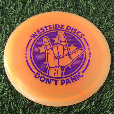 Translucent orange Westside Discs VIP Ice Orbit Moonshine Glow Gatekeeper with a purple Don't Panic Tour Series stamp.