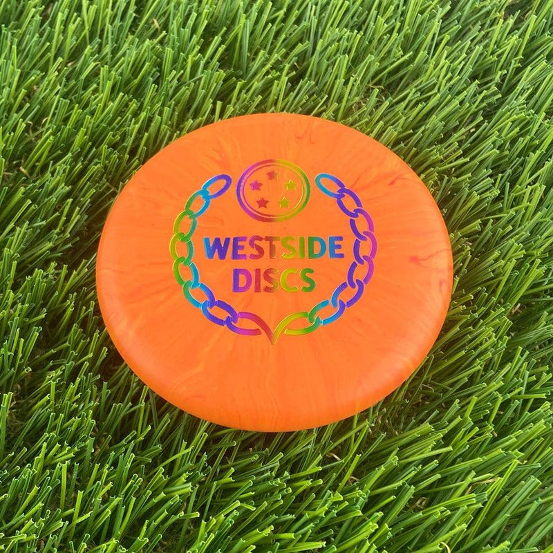 Orange Westside Marker Origio Burst disc golf coin mini with a rainbow "Westside Discs" chain-link logo.