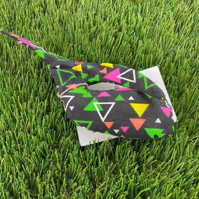 Black Whale Sacs grip bag tied with twine, featuring neon pink, yellow, green, and white geometric triangles.