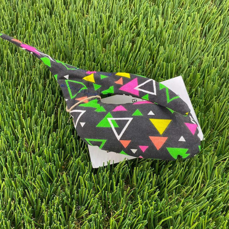 Black Whale Sacs grip bag tied with twine, featuring neon pink, yellow, green, and white geometric triangles.