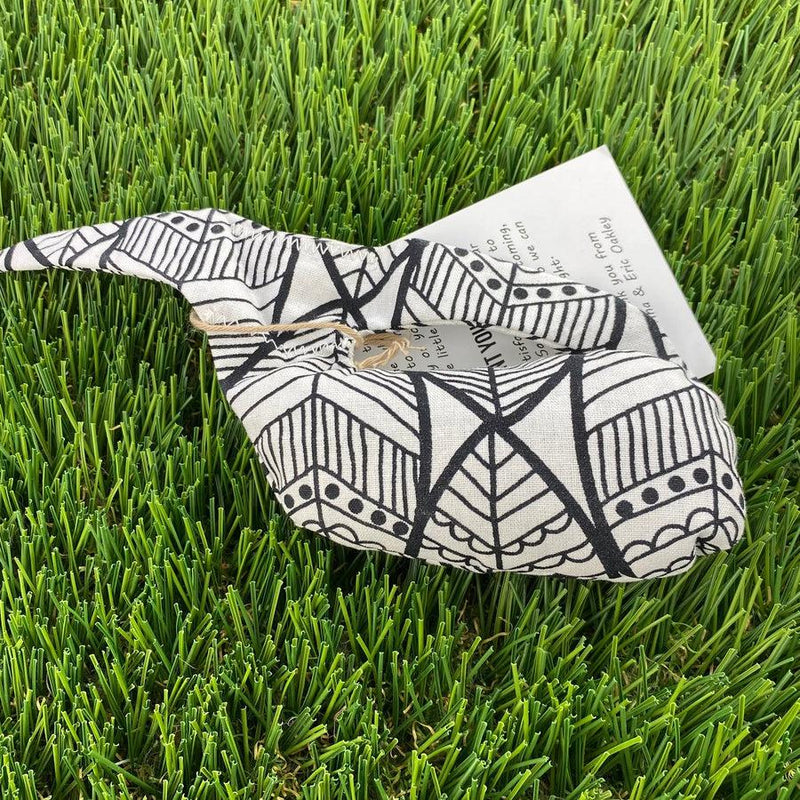 A black and white patterned Whale Sacs grip bag tied with twine, featuring intricate geometric designs.