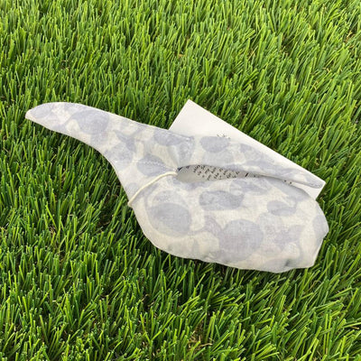A grey and white patterned Whale Sacs grip bag tied with a string, featuring printed instructions visible on the folded tag.