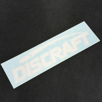 White "discraft" decal with a faint blue protective layer, angled diagonally on a dark textured background.
