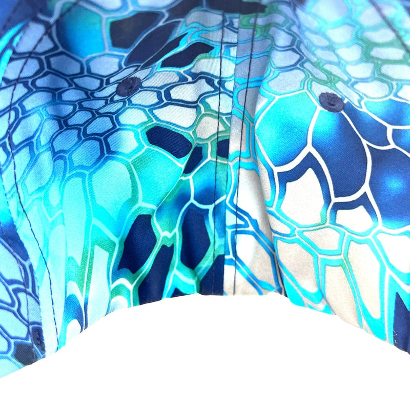 Close-up of a Yupoong Axiom Flexfit hat in a blue and teal Kryptek camouflage pattern with visible stitching.