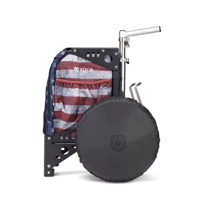 Black Zuca cart wheel cover with an embossed Zuca logo, obscuring a wheel and partially covering a patriotic bag.