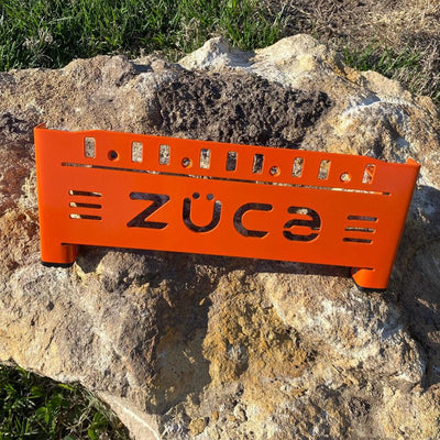 Bright orange ZUCA front wrapper backpack disc golf cart frame with a cutout logo and black leg caps.