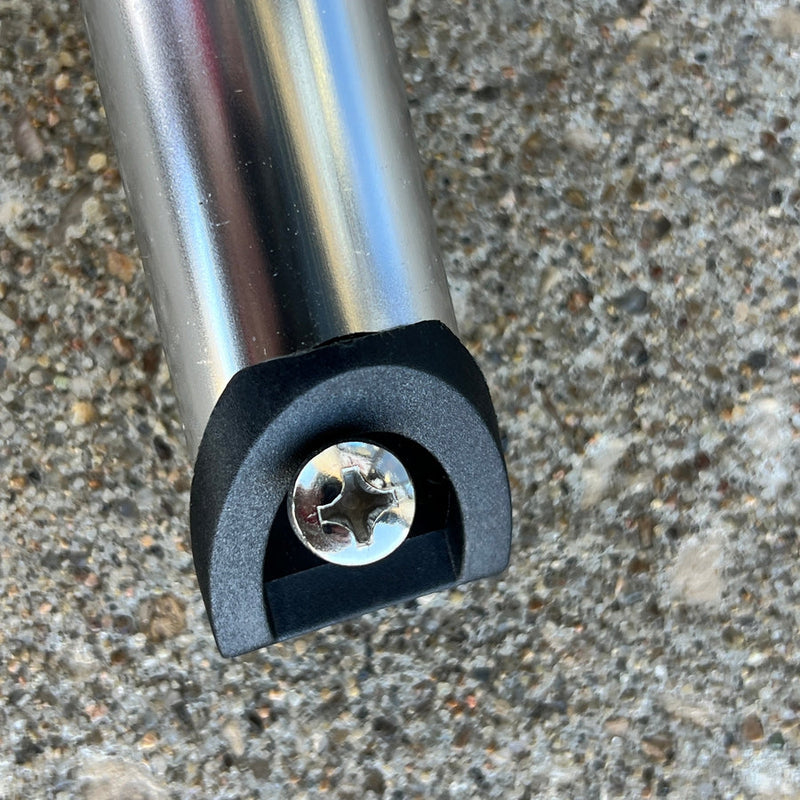 Close up of a shiny silver Zuca cart telescoping handle with a black plastic end cap and visible screw.